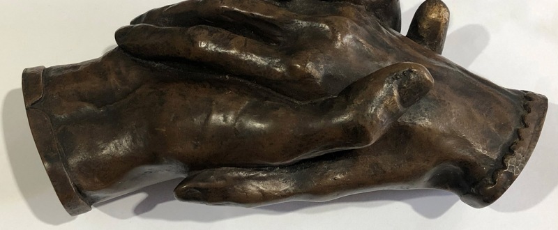 sculpture of two hands clasping each other